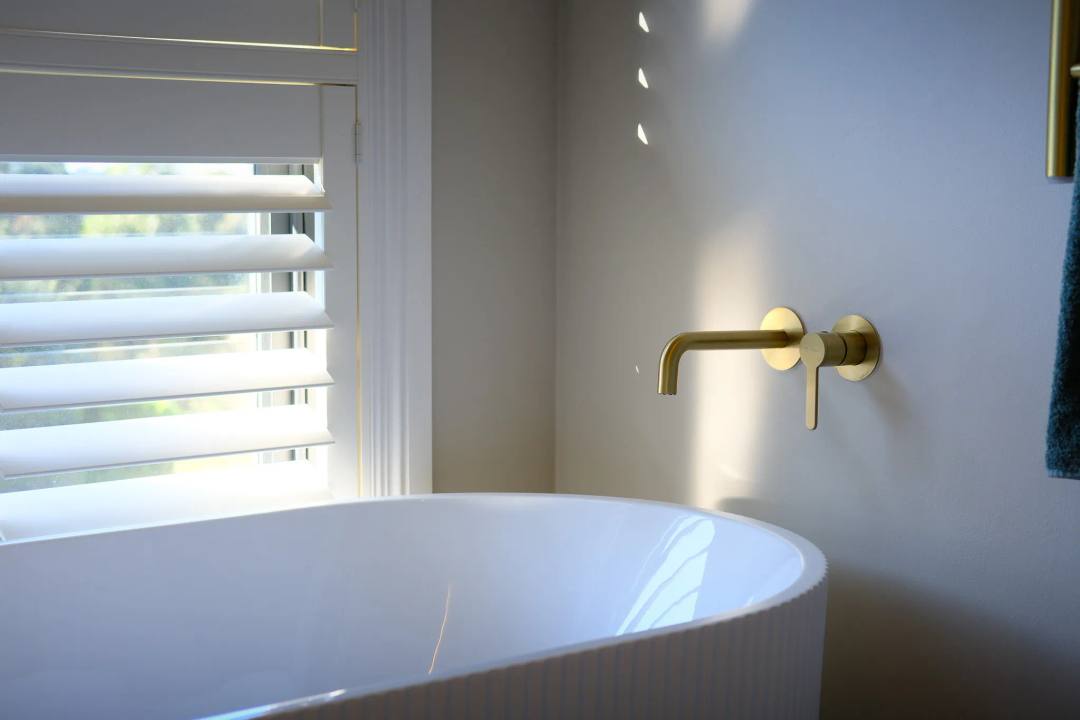 Modern shower and tap finishes for 2025 bathroom interiors. The Meissen Attivo wall mounted basin mixer in satin brass